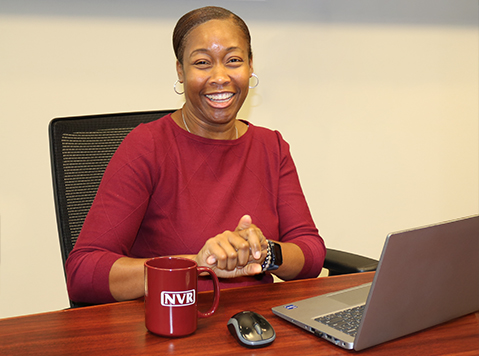 Smiling employee sitting a desk with her computer.